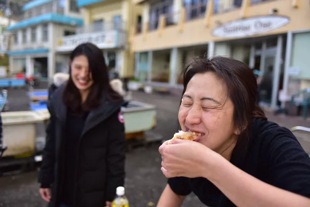 初潜りの後に餅を味わう仲間