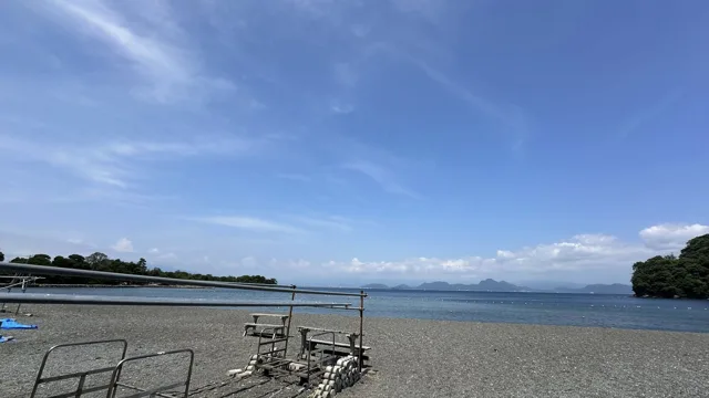 伊豆・大瀬崎(景観から推定)でのダイビング:2025年6月23日投稿日。大瀬崎とみられる海岸の砂利浜、穏やかな湾と青空。場所は景観から推定。