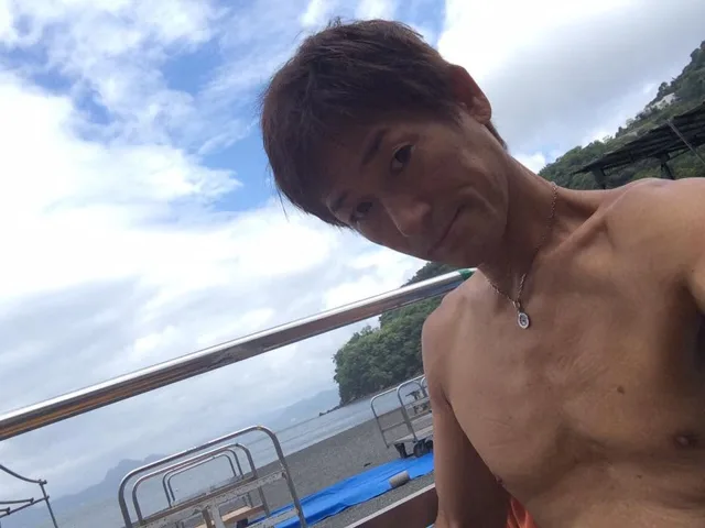 伊豆・大瀬崎でのダイビング：大瀬崎の海を背景に写るダイビング参加者
