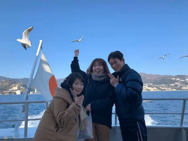 伊豆・熱海・初島航路でのダイビング：初島への船上でカモメと記念撮影する参加者